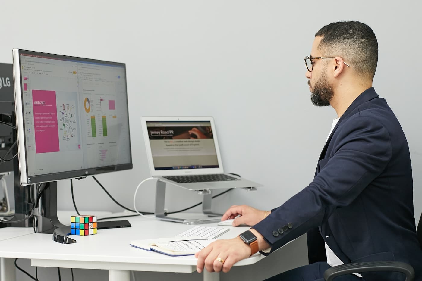 Compliance officer reviewing document audit trail reports on a dual-monitor workstation in a professional office