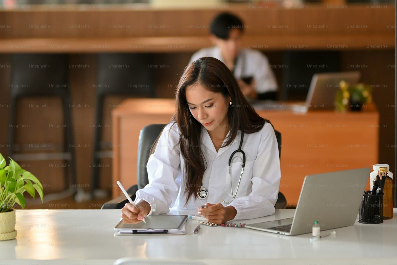 Care coordinator reviewing a longitudinal patient record spanning primary care, specialist, and hospital encounters