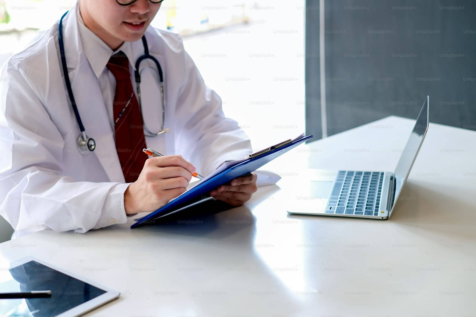 Multi-disciplinary care team reviewing a longitudinal patient record across a hospital and specialty clinic